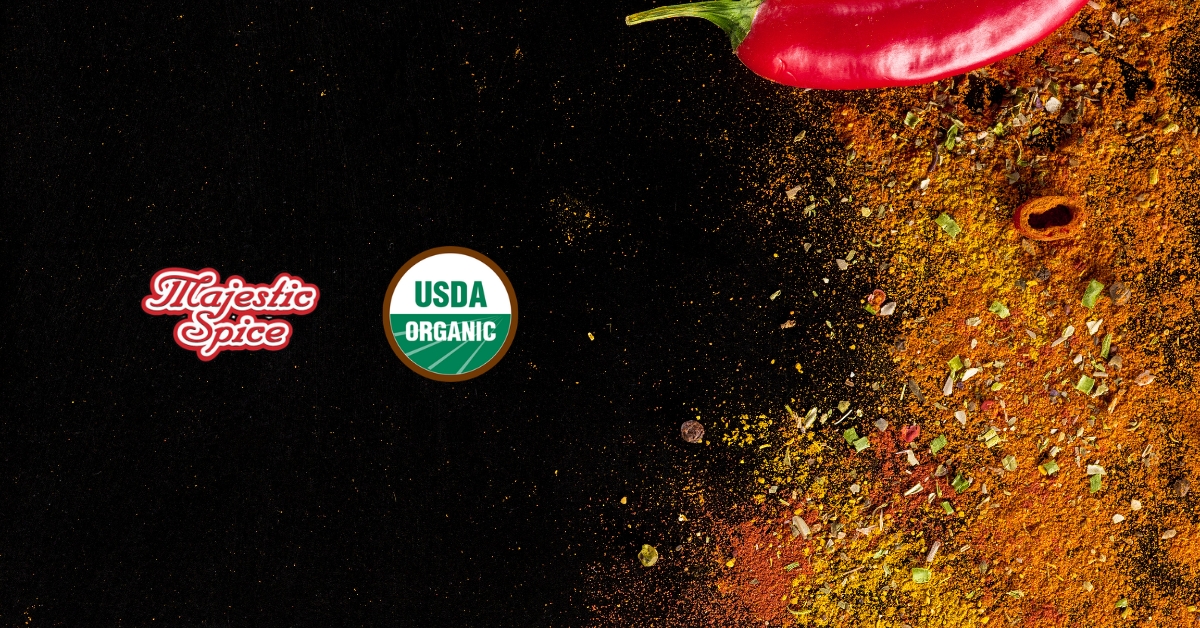 Majestic Spice Logo, the USDA organic logo, and in the right of the picture a chili in the corner and powdered spices like chili, curry, and others. Black background